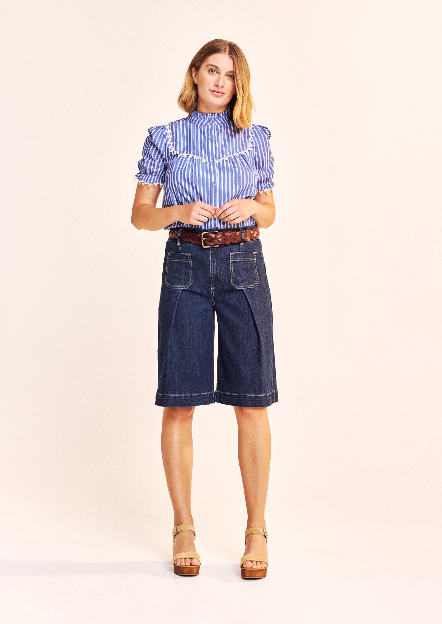 This beautiful piece by our new British brand ONE COLLECTIVE is in a classic blue with white stripes. As with every piece from this brand the attention to detail is exceptional. The A shaped blouse has a frill at the neck and a gathered bib front and back trimmed with a crisp white lace detailing. The slightly puffed short sleeves are gathered and again trimmed with a cotton lace. The fabric covered buttons add another dimension. The fit is true to size.