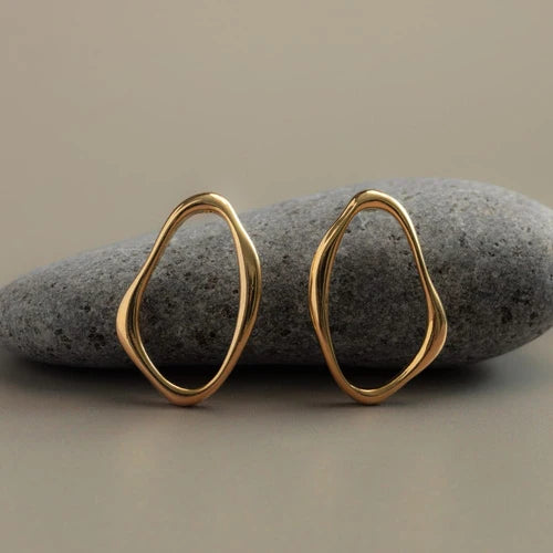 The Open Organic Oval Earrings from ORELIA feature a fluid open-shape silhouette inspired by natural, imperfect forms.