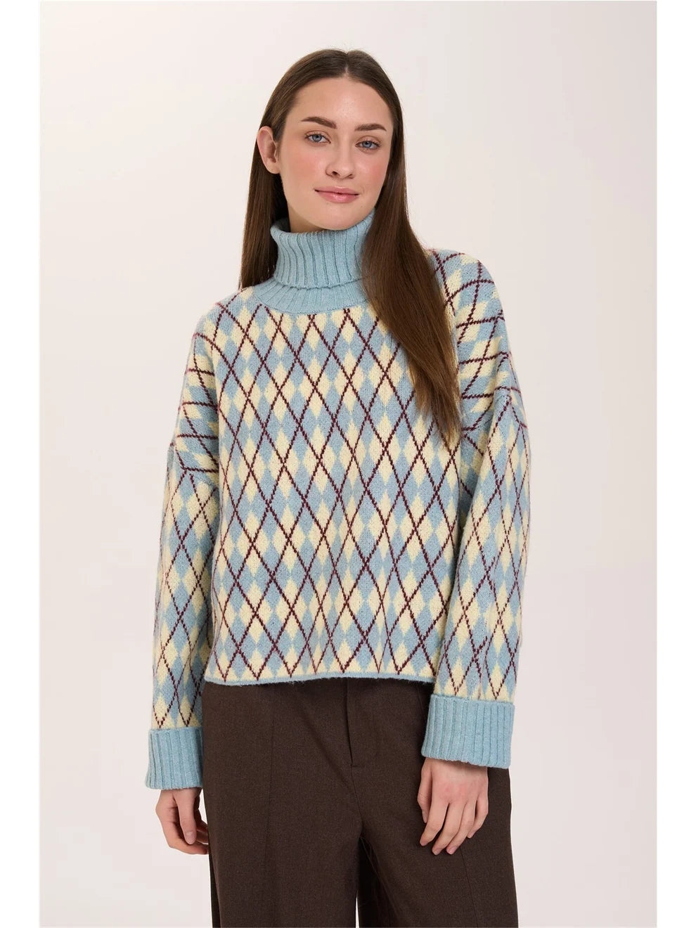 A relaxed-fit knitted jumper featuring a classic argyle pattern in light blue, cream and burgundy. The high roll-neck and wide ribbed cuffs add solid-colour accents. Dropped shoulders and a straight, relaxed cut create a comfortable fit.
