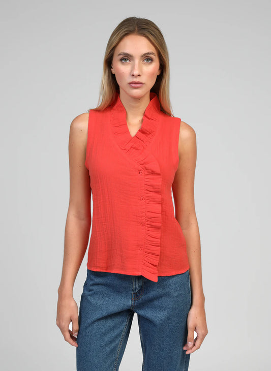 The Siloe Blouse by An'ge is a beautifully feminine piece with thoughtful design details. Featuring a delicate frill that frames the neckline and continues down the front, this sleeveless blouse is finished with an elegant off-centre button fastening for a contemporary twist.