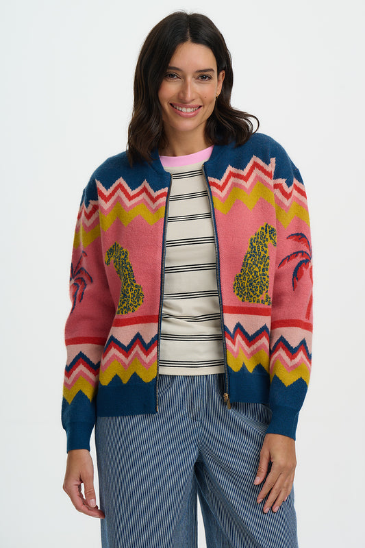 The Solana Knitted Bomber Jacket from SUGARHILL is a playful yet versatile knit designed with a relaxed fit and a centre zip fastening for easy layering. Crafted in a soft knit, it brings a casual edge to any outfit, perfect for throwing over tees and pairing with jeans. Two stylized leopards flank a palm tree beneath bold zigzag stripes, creating a vibrant, exotic, retro-inspired scene that makes this bomber a true statement piece that’s both cosy and stylish.