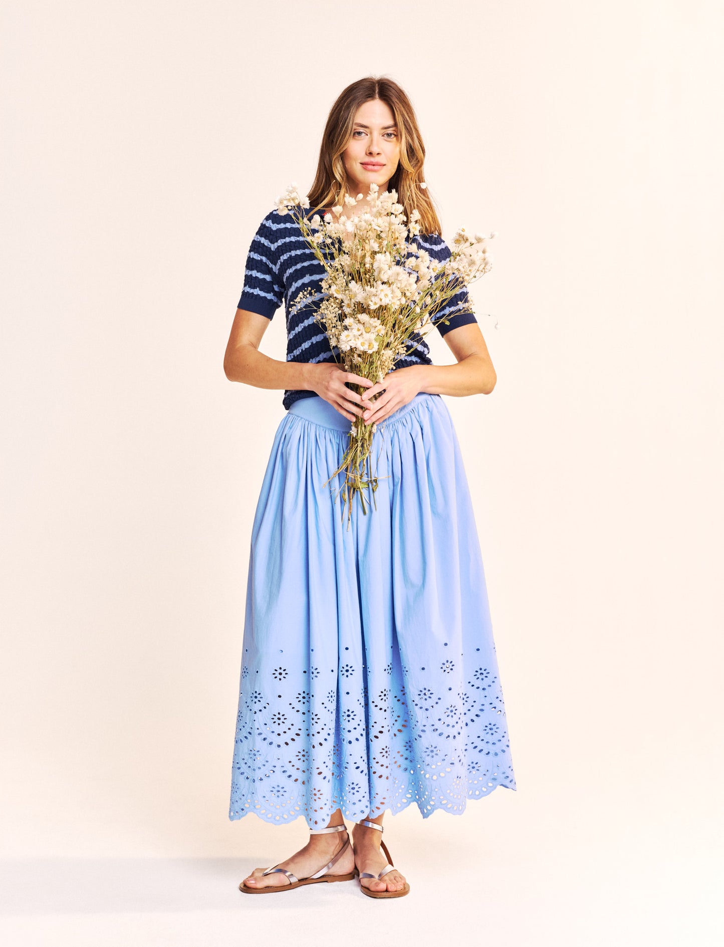 Another stunning piece from our new brand One Collective. A midi length skirt with a zip and single button to fasten at the back. In a beautiful cotton poplin fabric and half lined this piece is perfect for the Summer weather. The broderie Anglais at the hem adds a touch of class.
