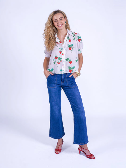 The New Day Originals Paddington Blouse in Strawberry is a delicate, stylish top made from 100% cotton. It showcases lace detailing on the collar, button placket, and sleeves, a curved yoke with a gathered back for gentle volume, puffed sleeves, and a slightly extended back for a modern, flattering silhouette.