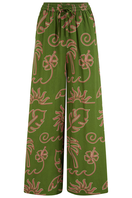 Say hello to the Trinny Wide Leg Trousers from SUGARHILL — flowing, relaxed, and utterly holiday-ready, these wide leg trousers are the kind of piece you'll reach for again and again all season long. Featuring a bold olive green and pink tropical outline print, the Trinny trousers bring a pulled-together, coordinated feel, whether worn as part of the full set or mixed back with a simple tee or fitted knit. The elasticated high waist with a drawstring tie keeps the fit comfortable and adjustable, while deep 