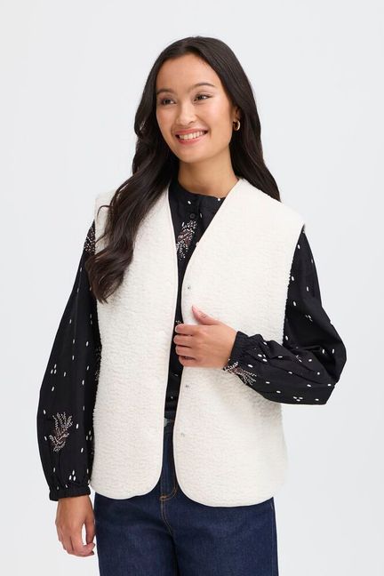 Women's fleece vest from FRANSA offers relaxed fit and versatile style for layering. Features a V-neckline, snap button closure, and soft, textured finish for all-day comfort. Ideal for casual or semi-casual outfits. Fits true to size.